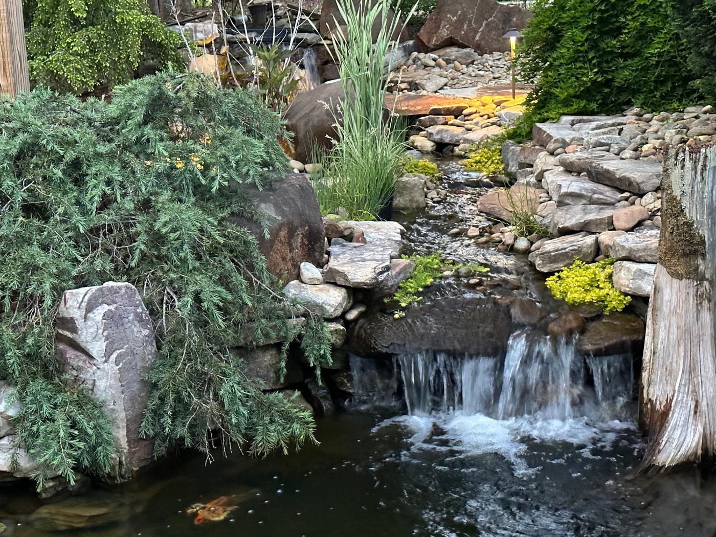 A waterfall that is in the middle of some rocks.