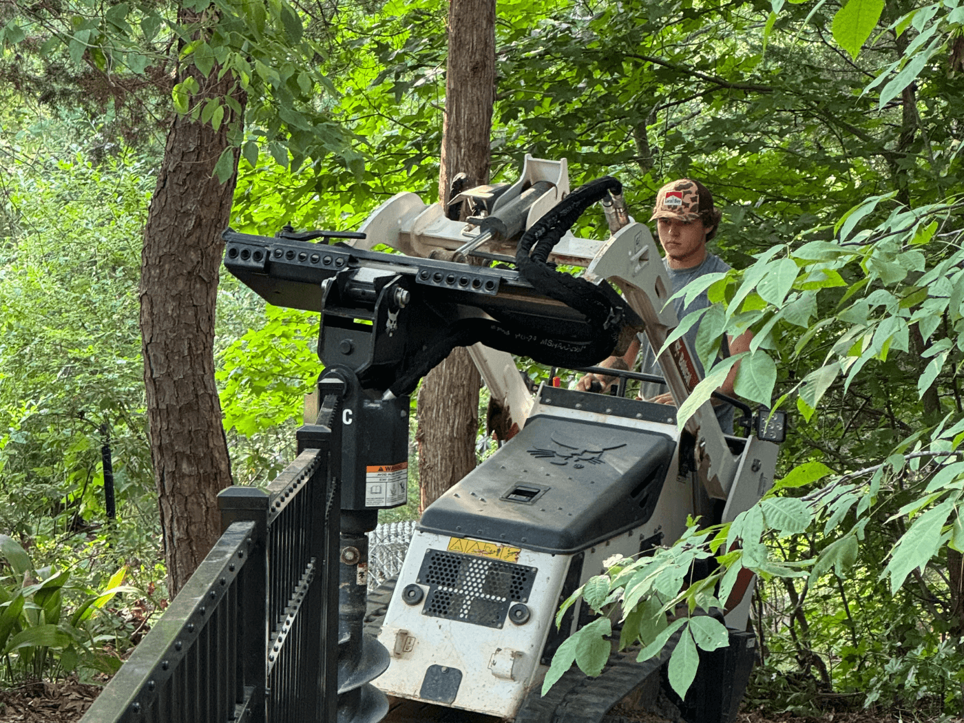 A man standing next to a camera on top of a tree.