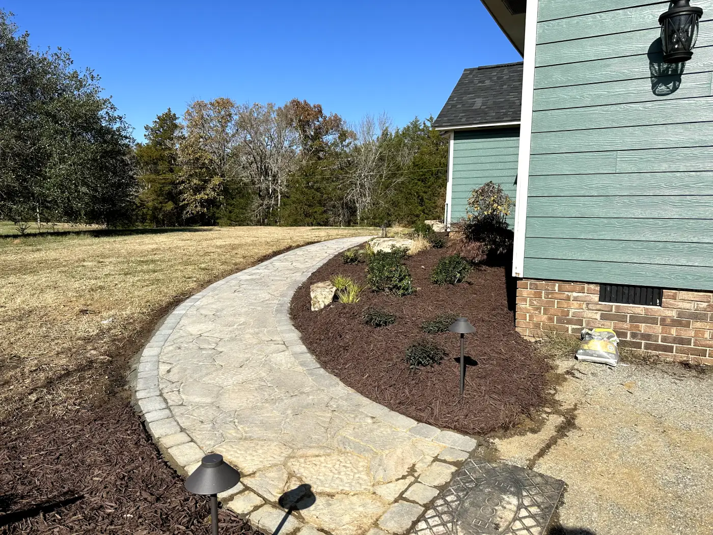 A walkway with a stone path and landscaping.